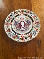 Full view of the commemorative plate showing the floral border and central Queen Elizabeth silhouette design