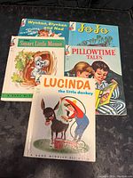 Four 1960s hardback children's books including 'Wynken, Blynken and Nod', 'JoJo', 'The Smart Little Mouse', and 'Lucinda the Little Donkey' with illustrated colorful covers.