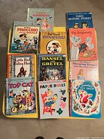 Photo showing eleven vintage Golden Books including titles like Pinocchio, The Aristocats, Hansel and Gretel, Santa's Toy Shop, and others with wear consistent with fair condition.
