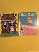 Photo showing two children's books: 'The House That Jack Built' and 'Baby Sister', both Rand McNally Elf Books, with illustrated covers.