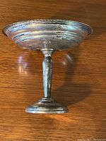 Side profile view of sterling silver pedestal candy dish showing weighted base and stem.