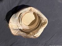 Overhead view of white detachable collars stacked inside the fabric and leather collar carrier pouch.