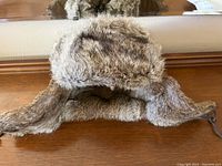 Front and side angled view of the rabbit fur hat showing ear flaps and fur texture.