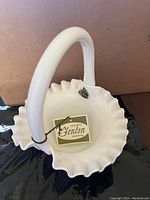 Top-down view of Fenton hobnail milk glass basket showing ruffled edge and attached label