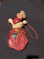 Front view of cowgirl purse showing doll head, torso with red scarf, and red vinyl skirt with decorative accents