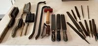 View of crowbars, hammer, wire and wooden bristle brushes, and 3 metal rasps/rasp files