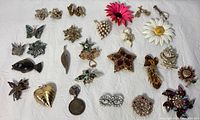 Photo showing entire collection of 29 pins on fabric, displaying variety of styles, colors, and sizes.