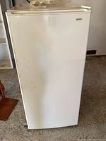 Front view of Kenmore white upright freezer with handle on upper door edge.