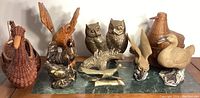 Wide view of all bird-themed decor items including brass owls, roadrunner, ceramic birds, wooden eagle, and wicker baskets