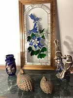 Overview of all five pieces: stained glass panel, cobalt vase, ceramic magpie figurine, two metal partridges