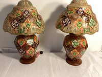 Two painted papier-mâché lamps showing full fronts of bases and shades