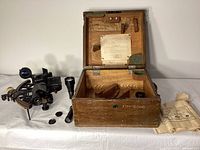Full lot overview showing sextant, wooden case, telescopes and accessories on table