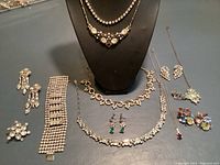 Overview of all jewelry pieces arranged on table with display bust