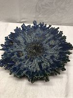 Top view of blue glaze starburst decorative plate showing textured radiating pattern
