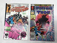 Side-by-side photo of Amazing Spider-Man #253 on the left and Marvel Team-Up #115 on the right, both Marvel comic books with vibrant covers.