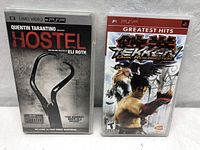 Front view of both PSP UMD game cases: Quentin Tarantino Hostile movie and Tekken Dark Resurrection game.