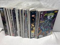 Comic books packed standing up in clear plastic sleeves showing many different issues.