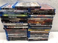 Stack of 45 Blu-ray and DVD movie cases showing a mixed lot including action, thriller and TV series titles