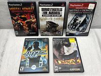 Overview of 5 PlayStation 2 game cases including Mortal Kombat Shaolin Monks, Brothers in Arms Earned in Blood, Medal of Honor European Assault, 007 Agent Under Fire, and Devil May Cry 2