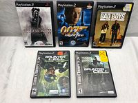 Five PlayStation 2 game cases: Blade II, 007 Nightfire, Bad Boys Miami Takedown, Tom Clancy's Splinter Cell Chaos Theory, Tom Clancy's Splinter Cell