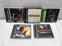 Top-down photo showing all 5 PlayStation game cases with cover art faces up, games include Star Wars Masters of Teräs Käsi, Metal Gear Solid, Alien Trilogy, 007 The World Is Not Enough, and Resident Evil Survivor.