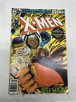 Front cover of The Uncanny X-Men #117 comic book showing X-Men characters and shadowy villain hand