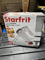Box front showing product image, brand Starfrit, 5-speed hand mixer, and capacity info.