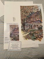 Top view of the art print showing the detailed fall scene of a house with flowers and trees and the certificate of authenticity in front.
