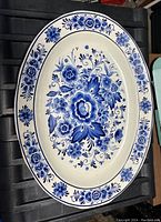 Top view of the oval platter showing central blue floral design and border on white porcelain surface.