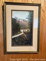 Full view of framed original artwork depicting a scenic landscape with road, lake, trees and mountain background.