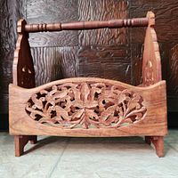 Front view showing carved floral design and wooden handle