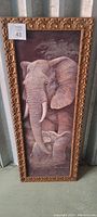 Full view of the framed artwork of an adult elephant and baby elephant in purples and muted tones with an ornate gold frame.