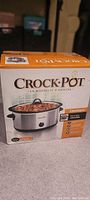 Box of Crock-Pot slow cooker showing model and packaging with images and text details.
