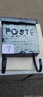 Front view of the antique metal post box showing 'POSTE' text and curved mounting brackets.