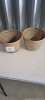 Two natural bamboo pots with concentric circle design, light brown color