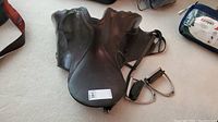 Front view of saddle with attached stirrups and leathers