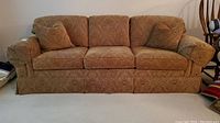 Full front view of the sofa showing overall condition and upholstery pattern