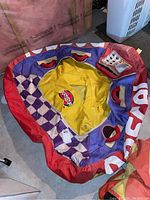 Two Rascal watersport towing tubes shown inflated from above, highlighting the red outer edges, purple and white checkered patterns, and yellow seating areas with multiple handles.