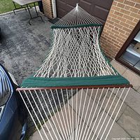 Top-down angled view of the Carolina double rope hammock showing green padded edging, wooden spreader bar, and white ropes.