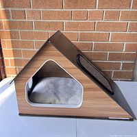 Photo showing the side view of the designer cat house with a soft cushion inside and wooden finish sides.