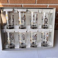 Full box view showing the set of 8 Libby Glass hostess glasses with clock designs in original packaging.