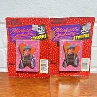 Front view of two sealed Michael Jackson peel away sticker sets showing original packaging with colorful Michael Jackson illustration.