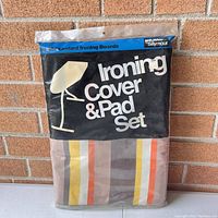 Front of the vintage ironing board cover and pad set package showing product branding and packaging design with colors and text.