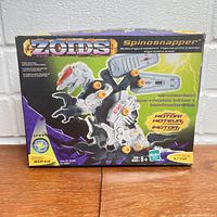 Front view of the original sealed box of the ZOIDS Spinosnapper robot toy showing the assembled figure and branding.