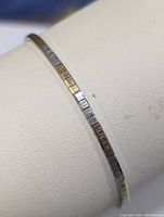 Close up photo of the sterling silver multicolor square link bracelet on a display stand showing texture and color variation of the square links.