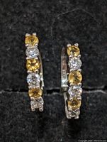 Close-up of front of both earrings showing alternating citrine and clear stones.