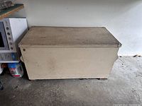 Full front view of the large painted storage chest showing overall exterior wear and marks.