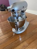 Silver KitchenAid Custom mixer on hardwood floor showing bowl and flex-edge beater