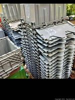 Stack of grey plastic finger locking totes showing finger-lock tabs and grated bottoms