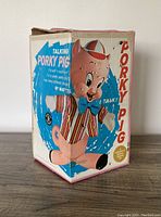 Original box showing the colorful side with Porky Pig character and text describing the talking feature